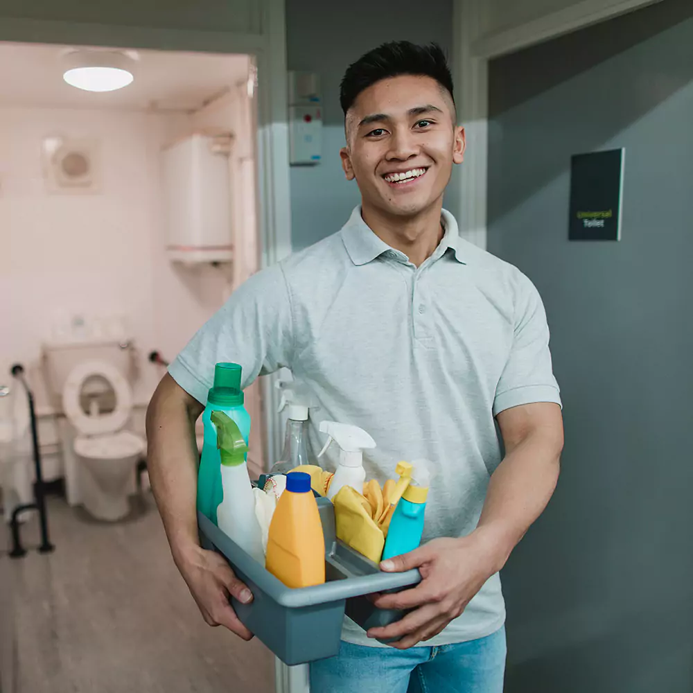 A house cleaner in from of a bathroom