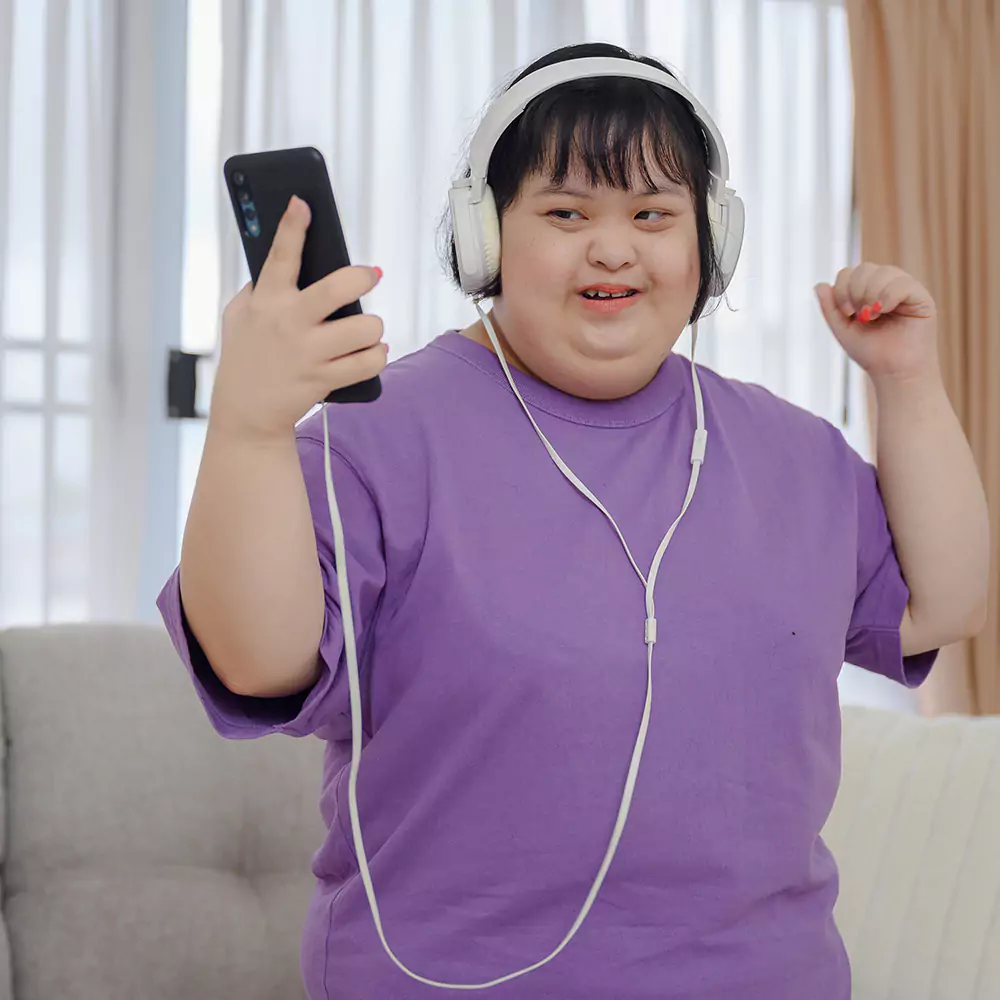 Down syndrome woman dressed in purple dancing indoors